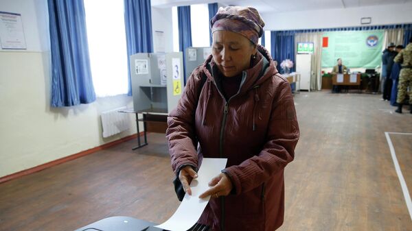 Женщина голосует на избирательном участке во время выборов в Жогорку Кенеш  - Sputnik Кыргызстан