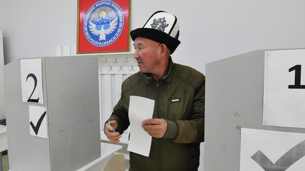 Избиратель держит бюллетень во время парламентских выборов в Жогорку Кенеш - Sputnik Кыргызстан