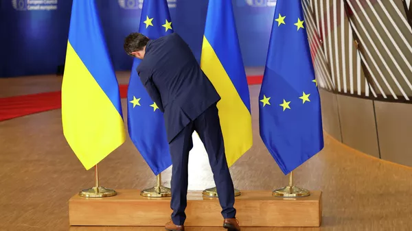 Протокол кызматкери Евробиримдиктин жана Украинанын желектерин тууралап жатат. Архив - Sputnik Кыргызстан