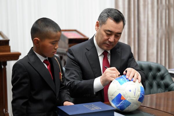 Садыр Жапаров Нурзаман Алмазбековду өзүнүн кол телефонун, ноутбук, топ жана китеп белек кылды. - Sputnik Кыргызстан