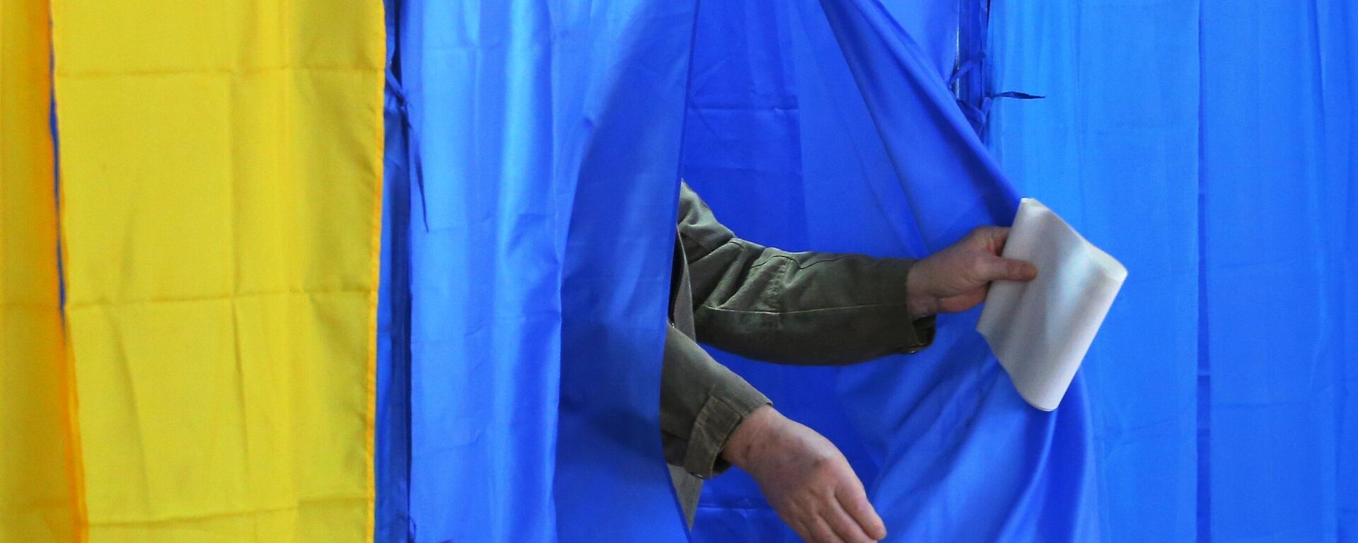 Мужчина во время голосования на выборах на избирательном участке в  Киеве. Архивное фото - Sputnik Кыргызстан, 1920, 30.12.2025