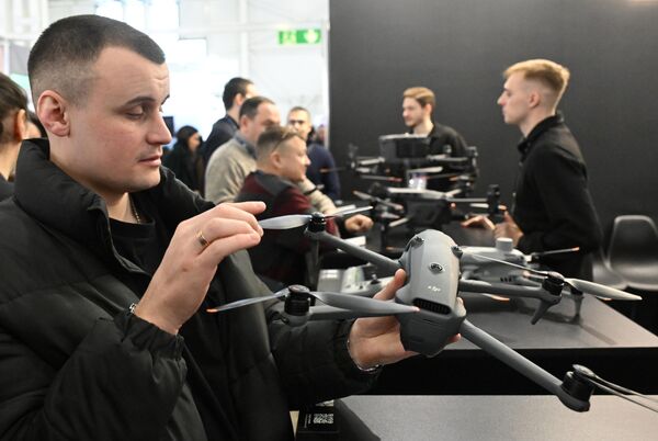 Посетитель держит квадрокоптер DJI. Эта китайская технологическая компания является одним из лидеров  на рынке  дронов для аэрофото- и видеосъемки. - Sputnik Кыргызстан