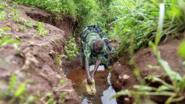 Африканская женщина набирает воду в источнике. Иллюстративное фото - Sputnik Кыргызстан