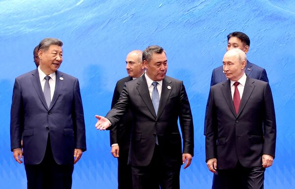 Президент Кыргызстана Садыр Жапаров жестом приглашает президента РФ Владимира Путина пройти  во время церемонии фотографирования на полях саммита ШОС в Бишкеке - Sputnik Кыргызстан