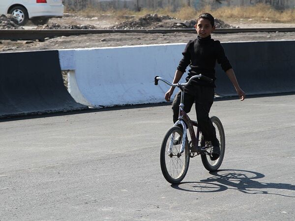 Жаңы салынган жолду велосипедчен бала текшерип жатат - Sputnik Кыргызстан