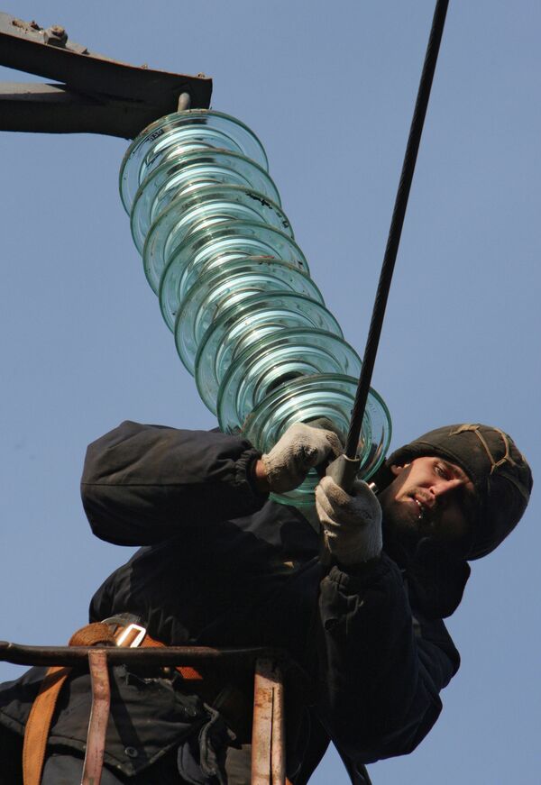 Монтажник ведет работы по установке электроизоляторов на высоковольтной линии электропередачи. Архивное фото - Sputnik Кыргызстан