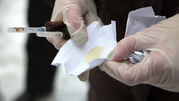 Мужчина держит пакетики с наркотическим веществом и шприцы в руках. Архивное фото - Sputnik Кыргызстан