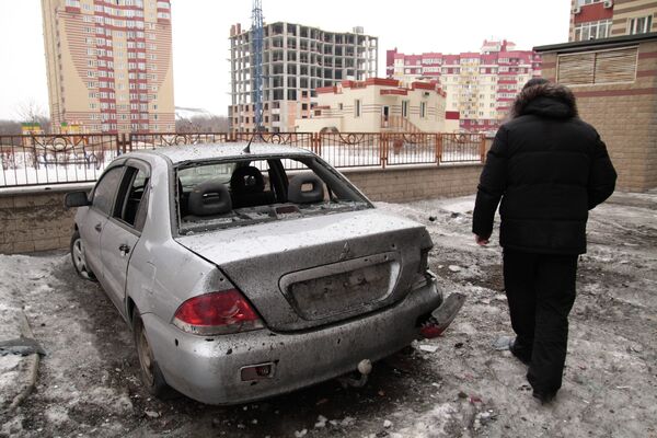 Мужчина рядом с поврежденным автомобилем после артобстрела Донецка. 18 января 2015 года. - Sputnik Кыргызстан