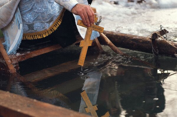 Перед нырянием в воду батюшка освящает Иордань. Архивное фото - Sputnik Кыргызстан