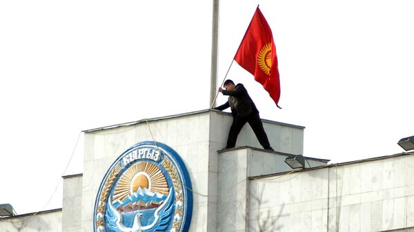 Кыргызстандын желегин Ак үйдүн крышасына орнотуп жаткан митингдин катышуучусу. Архив - Sputnik Кыргызстан