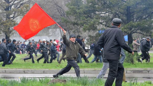 Участник антиправительственного протеста в Бишкеке 7 апреля 2010 года с флагом Кыргызской Республики - Sputnik Кыргызстан
