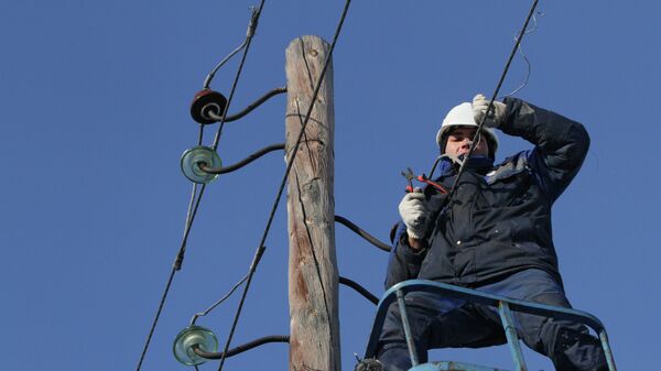 Электрик снимает провода со старой опоры линии электропередачи. Архивное фото - Sputnik Кыргызстан