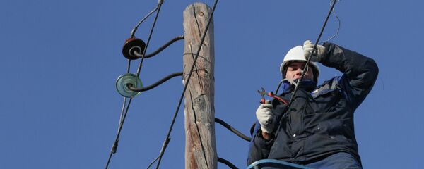 Электрик снимает провода со старой опоры линии электропередачи. Архивное фото - Sputnik Кыргызстан