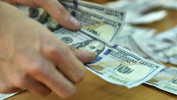 Мужчина считает долларовые купюры США. Архивное фото - Sputnik Кыргызстан