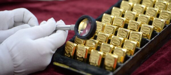 Рабочий рассматривает золотые слитки. Архивное фото - Sputnik Кыргызстан