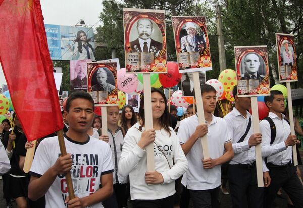 Молодые люди несут портреты участников ВОВ на акции Бессмертный полк. Архивное фото - Sputnik Кыргызстан