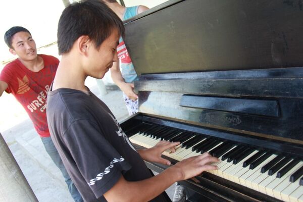Один из воспитанник пробует играть на фортепиано - Sputnik Кыргызстан