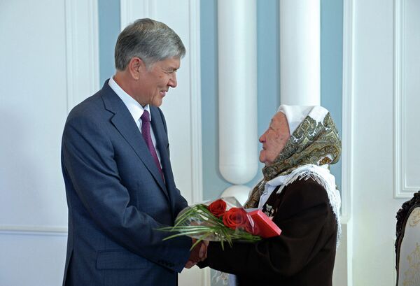 Президент Алмазбек Атамбаев жана көп балалуу эне. Архив - Sputnik Кыргызстан