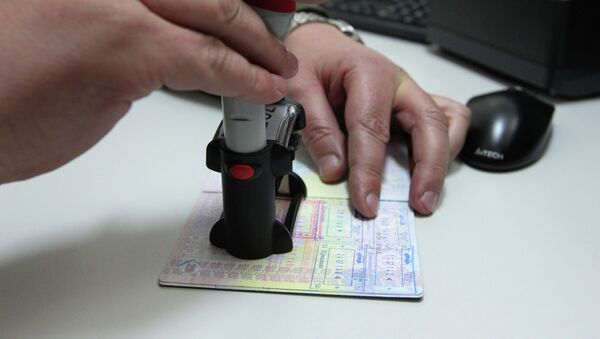 Сотрудник пограничной службы ставит в паспорт штамп. Архивное фото - Sputnik Кыргызстан