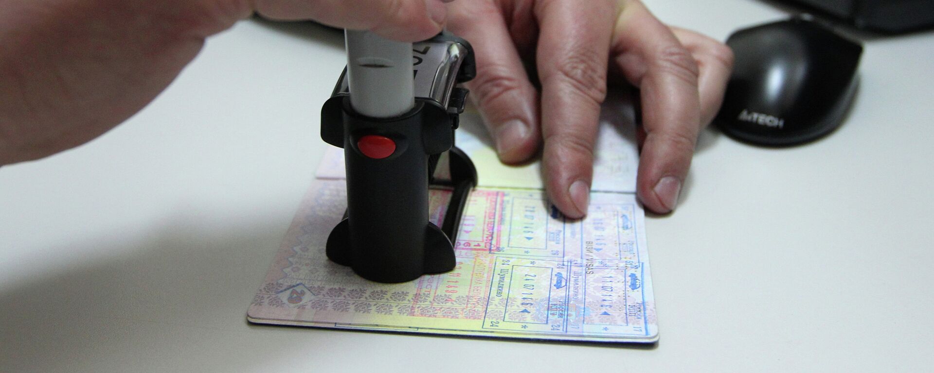Сотрудник пограничной службы ставит в паспорт штамп о пересечении границы. Архивное фото - Sputnik Кыргызстан, 1920, 27.10.2023