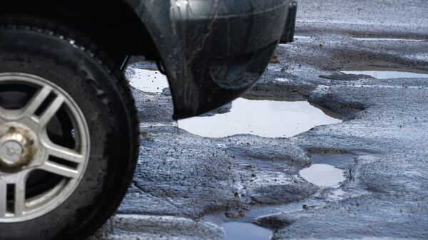 Автомобиль едет по разбитому дорожному покрытию. Архивное фото - Sputnik Кыргызстан