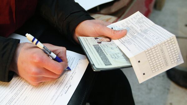 Сотрудник федеральной миграционной службы проводит проверку документов у иностранных рабочих. Архивное фото - Sputnik Кыргызстан