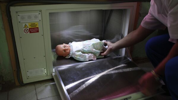 Врач достает куклу из специального контейнера, в который женщины могут анонимно оставлять нежеланных новорожденных детей. Архивное фото - Sputnik Кыргызстан