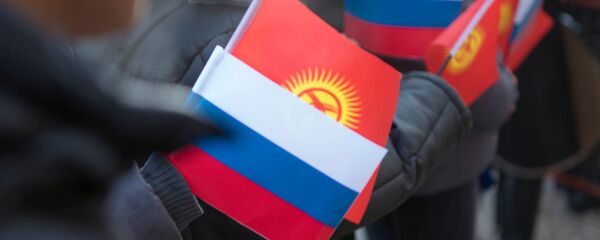 Архивное фото молодых людей, которые держат флаг Кыргызстана и России - Sputnik Кыргызстан