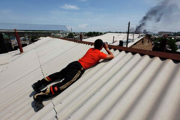 Подросток на крыше наблюдает за пожаром на улице. - Sputnik Кыргызстан
