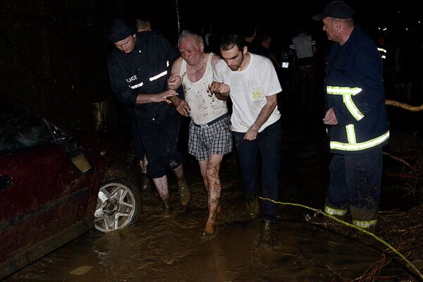 Грузинские спасатели помогают эвакуировать пожилого мужчину в затопленном районе в Тбилиси 14 июня 2015года. Проливные дожди вызвали повышение уровня воды реки Вере в грузинской столице. - Sputnik Кыргызстан