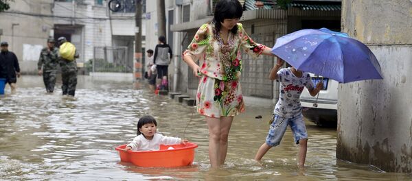 Женщина с детьми во время наводнения в Китае. Архивное фото - Sputnik Кыргызстан