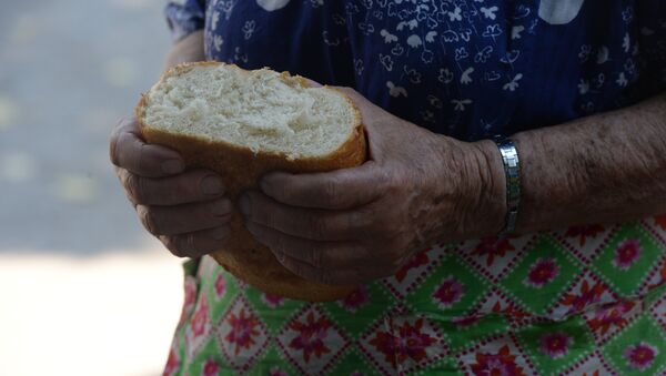 Пожилая женщина держит в руках хлеб. Архивное фото - Sputnik Кыргызстан