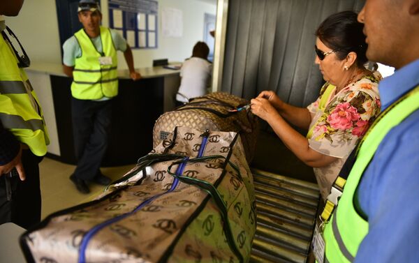 Женщина в аэропорту проходит контроль багажа - Sputnik Кыргызстан