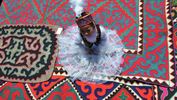 Девочка в национальном платье сидит на ковре из войлока - Sputnik Кыргызстан