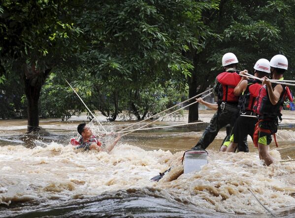 Около 5 млн человек пострадали от наводнений в центральных, юго-западных и восточных провинциях Китая Хунань, Дзянси и Сычуань. Спасатели вытаскивают мужчину из воды во время сильного наводнения, вызванного внезапным повышением уровня воды в реке Лицзян - Sputnik Кыргызстан