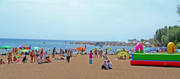 Люди отдыхают на пляже озера Иссыккуль. Архивное фото Люди отдыхают на пляже озера Иссыккуль. Архивное фото - Sputnik Кыргызстан