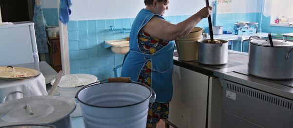 Повар раскладывает обед по группам на кухне. Архивное фото - Sputnik Кыргызстан