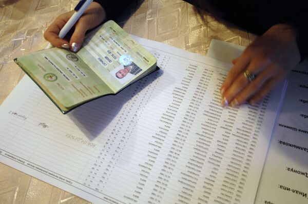 Член избирательной комиссии держит паспорт одного из голосующих. Архивное фото - Sputnik Кыргызстан