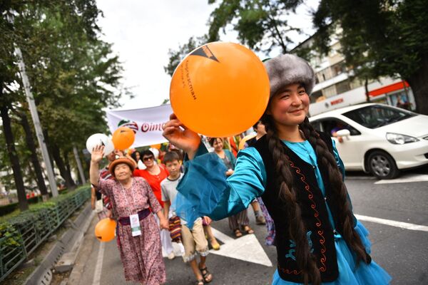 Участники шествия приветствовали жителей столицы, размахивая флажками и воздушными шарами - Sputnik Кыргызстан