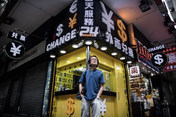 Человек стоит перед обменным пунктом в Гонконге, Китай. Архивное фото - Sputnik Кыргызстан