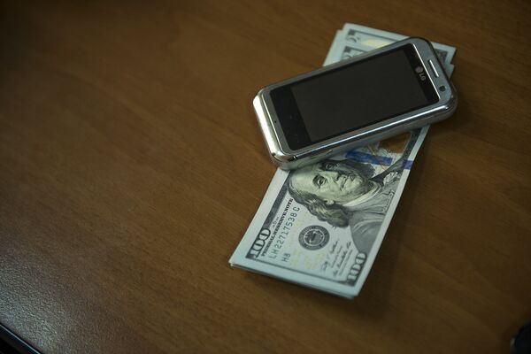 Мобильный телефон и сто долларовые купюры. Архивное фото - Sputnik Кыргызстан