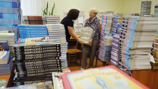 Учителя сортируют учебники в рамках подготовки школы к 1 сентября. Архивное фото - Sputnik Кыргызстан