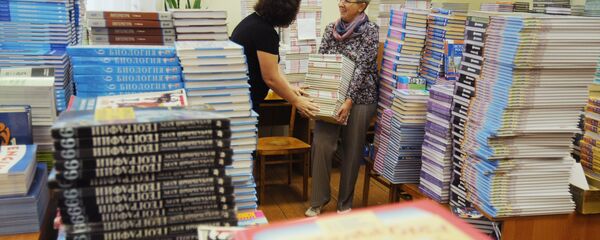 Учителя сортируют учебники в рамках подготовки школы к 1 сентября. Архивное фото - Sputnik Кыргызстан