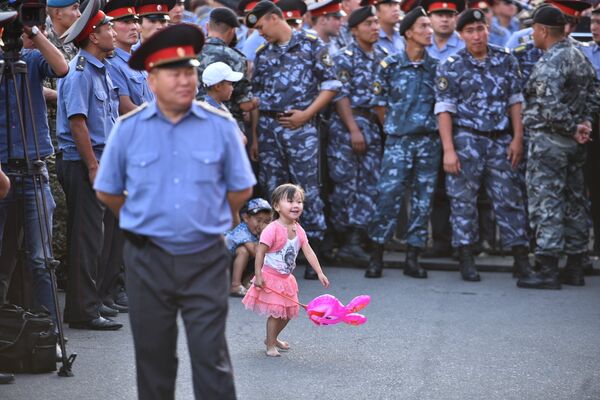 Маленькая девочка пробралась поближе к сцене через милицейский кордон - Sputnik Кыргызстан
