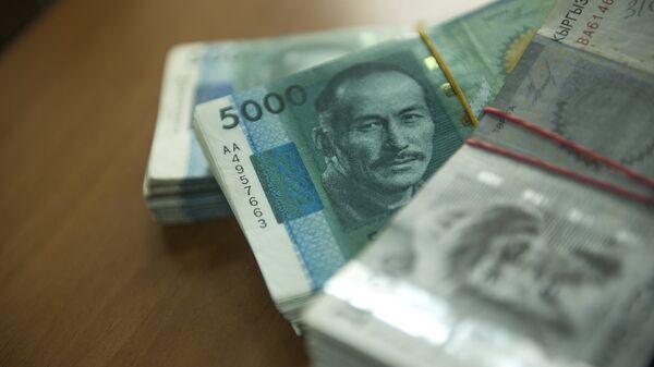 Кыргызская валюта номиналом в пять и одна тысячи сом на столе. Архивное фото - Sputnik Кыргызстан
