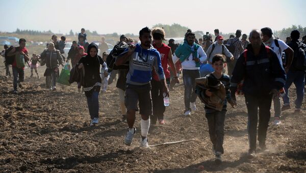 Беженцы из Сирии бегут в специально распределенный лагерь в Венгрии. - Sputnik Кыргызстан