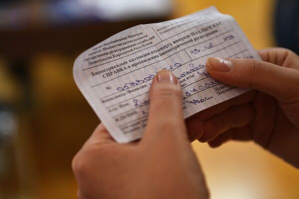 Человек держит справку о прохождении биометрической регистрации. Архивное фото - Sputnik Кыргызстан