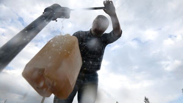 Житель села набирает воду из колонки. Архивное фото - Sputnik Кыргызстан