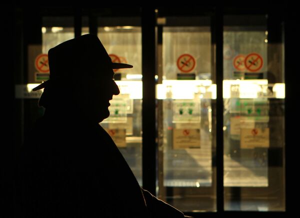 Мужчина на фоне знака запрета курения. Архивное фото - Sputnik Кыргызстан