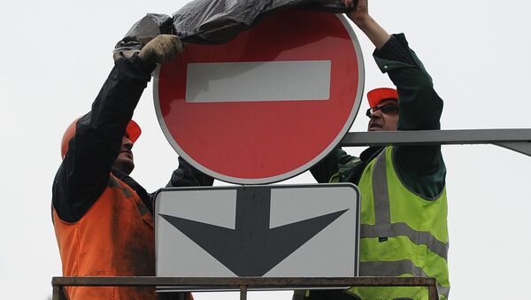 Дорожные рабочие завешивают знак, запрещающий выезд на полосу движения. Архивное фото - Sputnik Кыргызстан